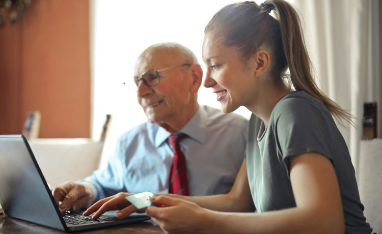 20250224-oudere-man-en-jongedame-bij-laptop-750x460